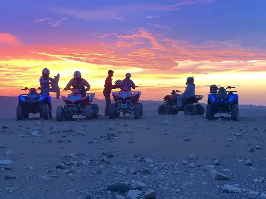 Tourists enjoying a quad biking experience at sunset in the Agafay Desert