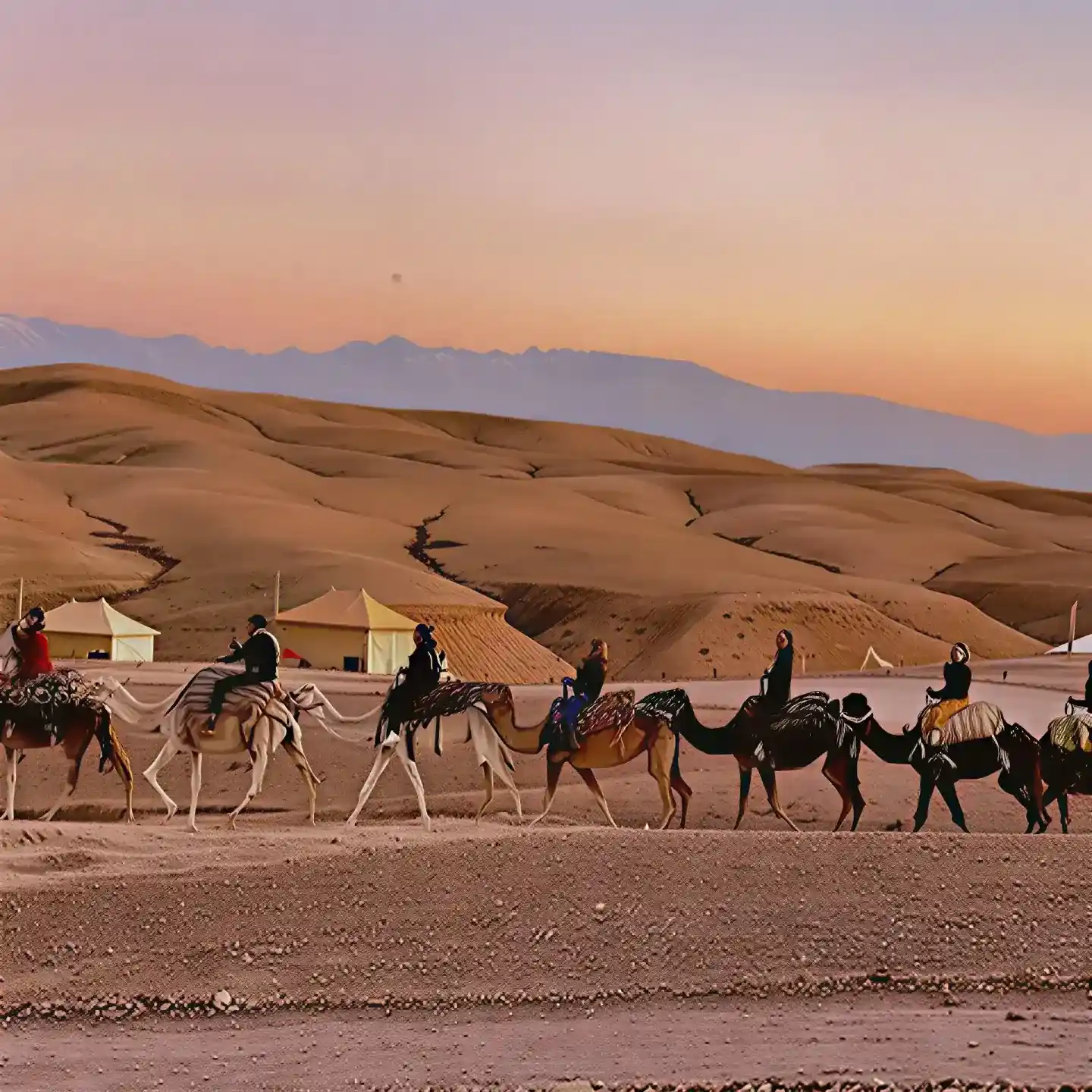 Guests enjoying an evening camel ride through the Agafay Desert landscape outside Marrakech