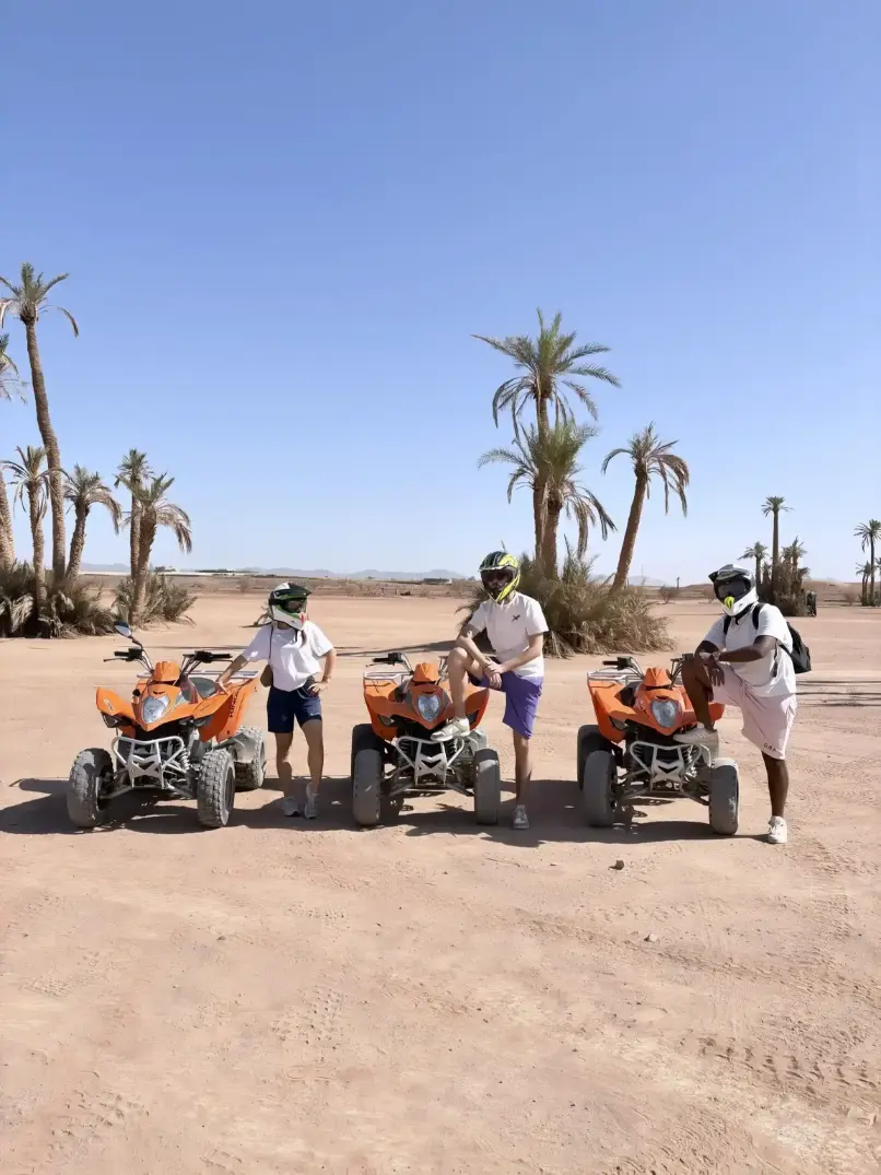 Three tourists posing with quad bikes during a private quad tour in Marrakech Palmeraie with hotel transfer included
