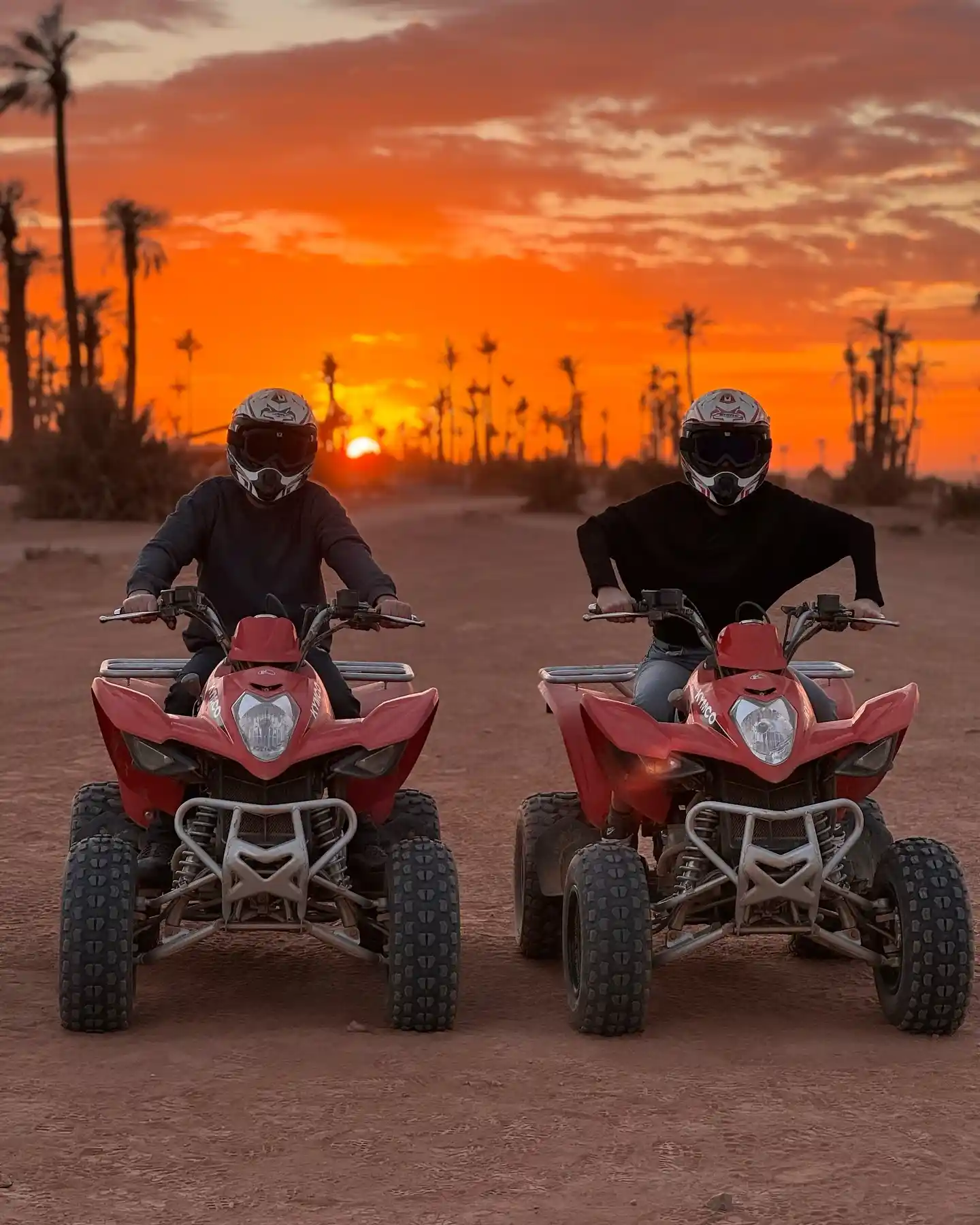 Two riders driving quad bikes during a sunset adventure in Marrakech Palmeraie.